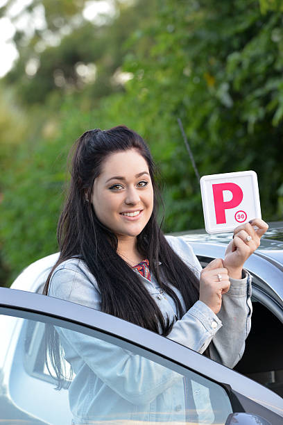 istock Young Australian female teenager learner driver holding a P plate 471665534