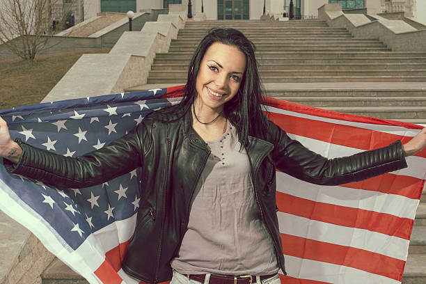 istock Young happy women with us flag outdoors smiling widely 471666138