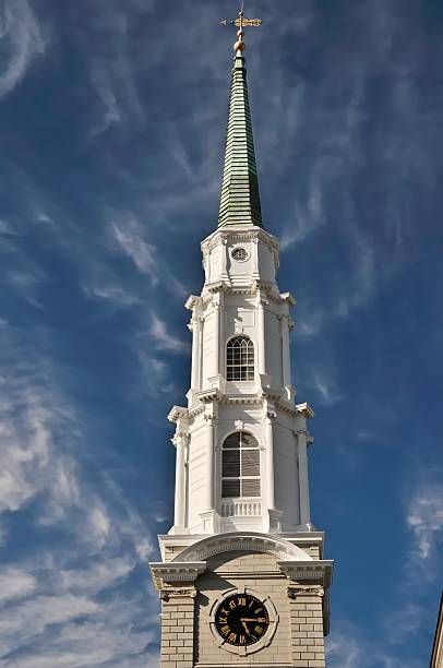 The steeple of the Presbyterian Church in Savannah Georgia against a bright blue sky with wispy clouds.