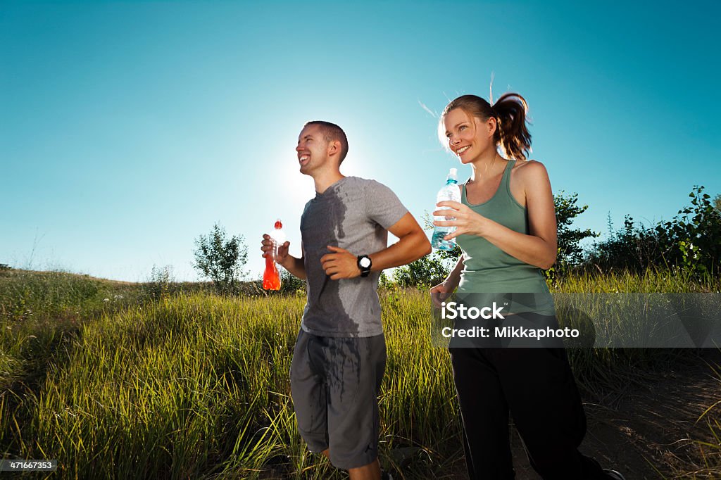 Giovane coppia jogging nella natura - Foto stock royalty-free di Adulto