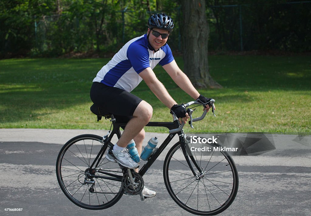 Jovem macho adulto acompanhante de bicicleta no parque na estrada de bicicleta - Foto de stock de Adulto royalty-free