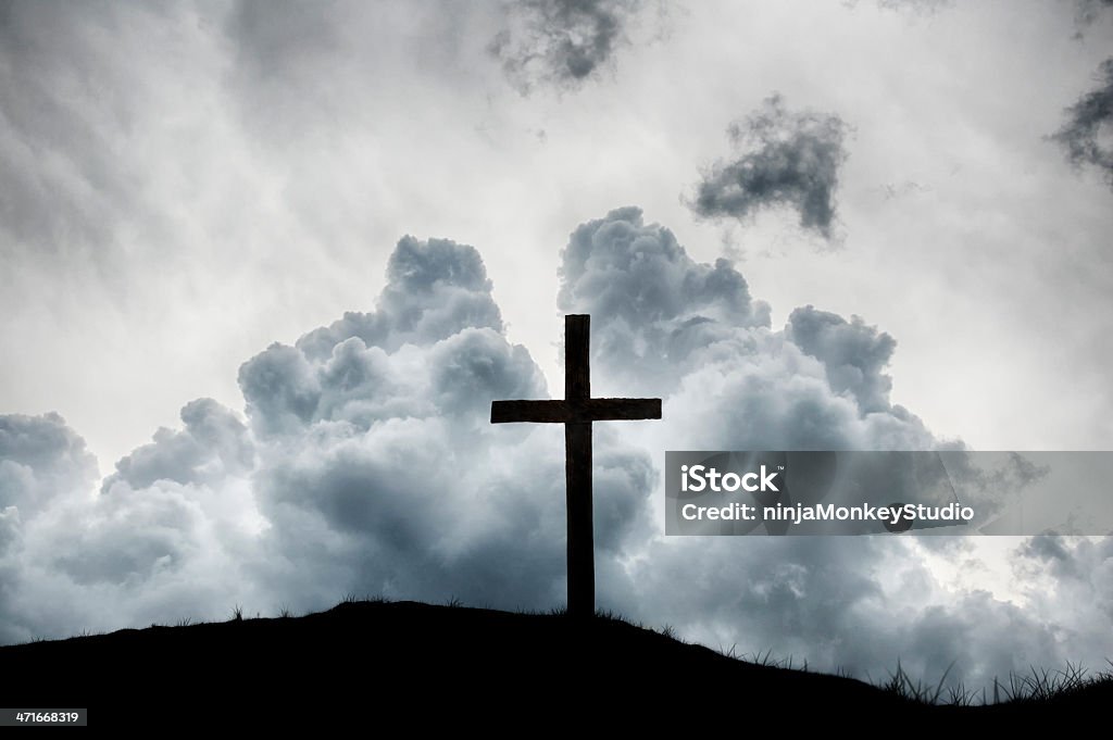 Christian Cross on Hilltop with Dramatic Clouds A beautiful background of the Christian cross. Cross Shape Stock Photo