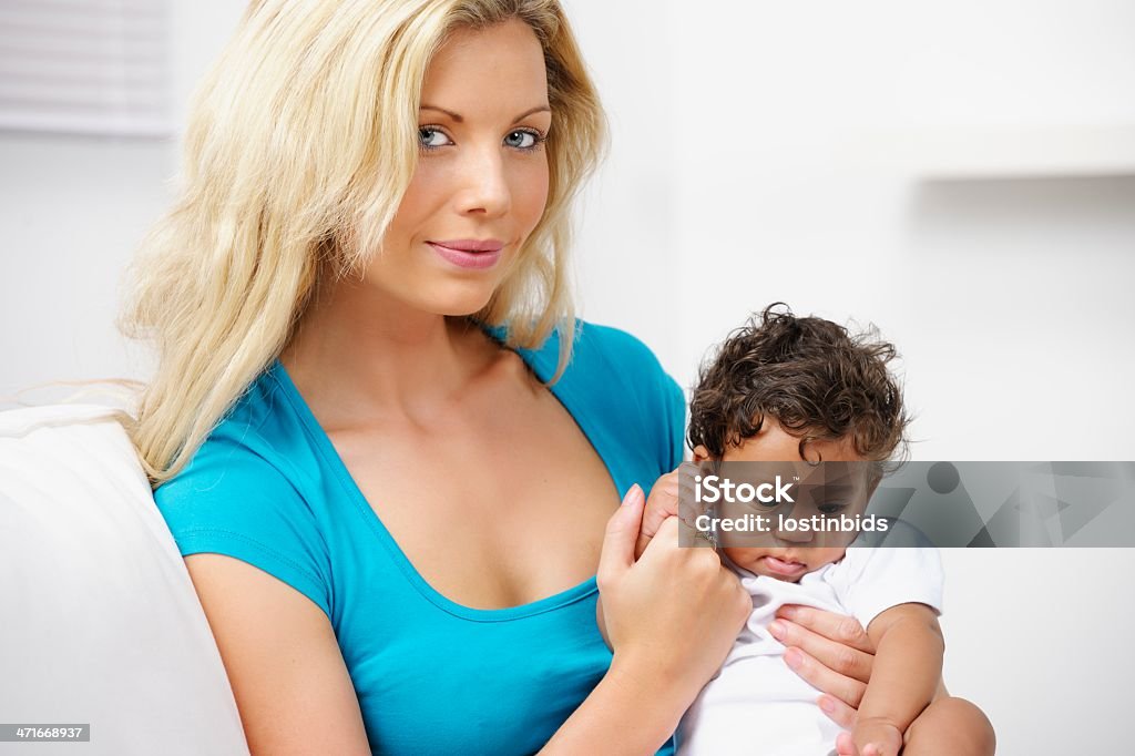 Loira jovem mulher segurando um bebê - Foto de stock de 0-1 Mês royalty-free