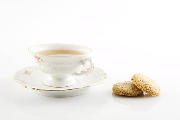 istock Old-style vintage cup of tea with cookies on white background 471669514