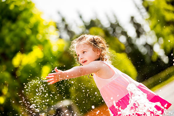 istock Cheerful girl splashing water with hand 471670521