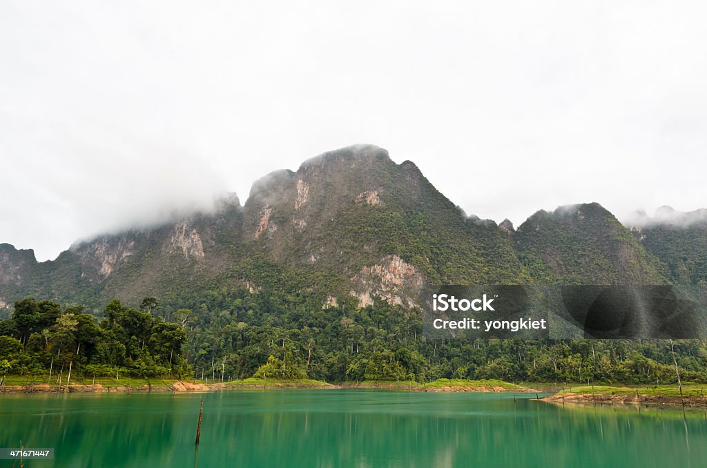 High mountains and green water.. High mountains and green water in morning at Ratchaprapha Dam, Khao Sok National Park, Surat Thani Province, Thailand. Asia Stock Photo