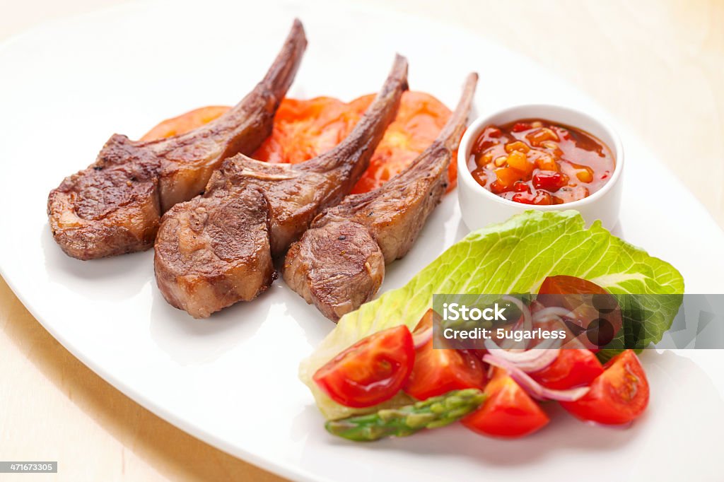 Lamb chops with asparagus salad and tomato salsa Lamb chops with asparagus salad and grilled tomato salsa Roasted Stock Photo