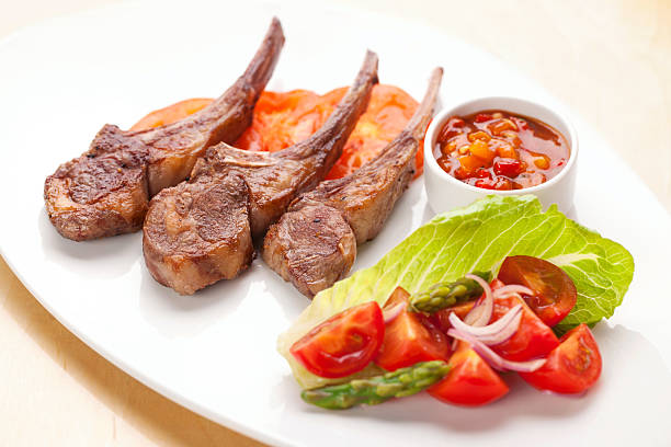Lamb chops with asparagus salad and tomato salsa stock photo