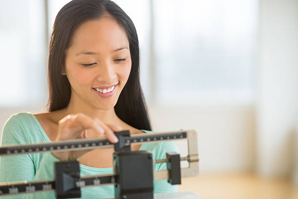istock Happy Woman Using Balance Weight Scale 471674433