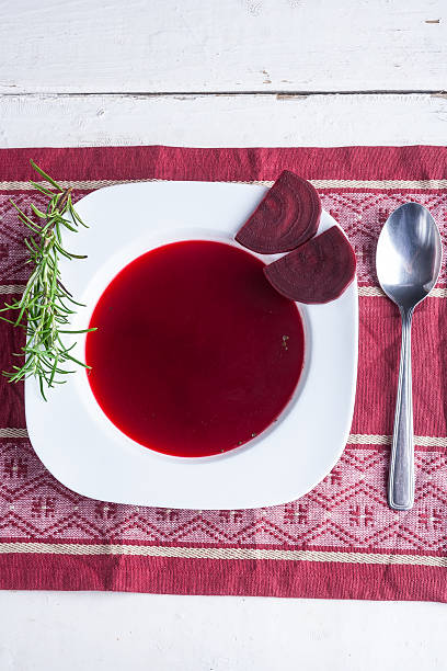 Borscht soup with fresh rosemary in white plate