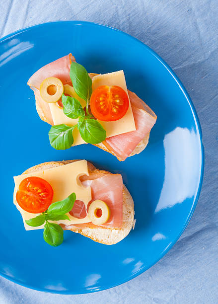 istock Small sandwiches with smoked ham, cheese and cherry tomato 471675544