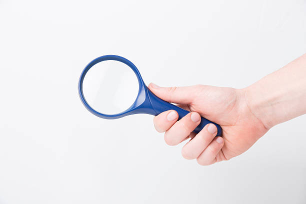 istock Man's hand, holding classic styled magnifying glass, closeup 471675740