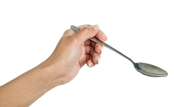 istock spoon in his hand on a white background 471676654