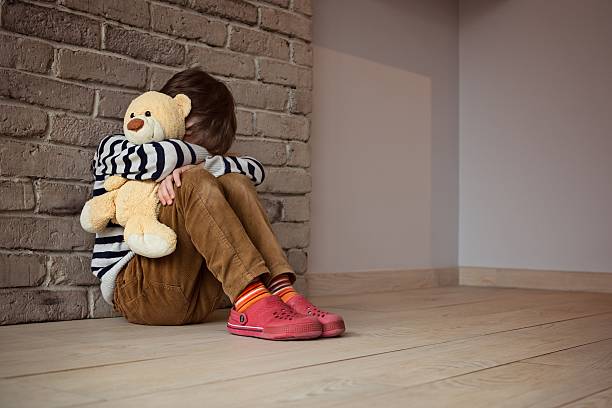 悲しげな少年ラウンジを、壁に絶望 - sadness child little boys loneliness ストックフォトと画像
