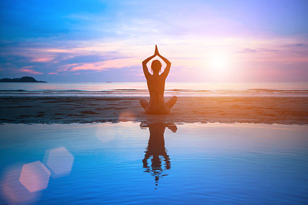 istock Silhouette young woman practicing yoga on the beach 471678061