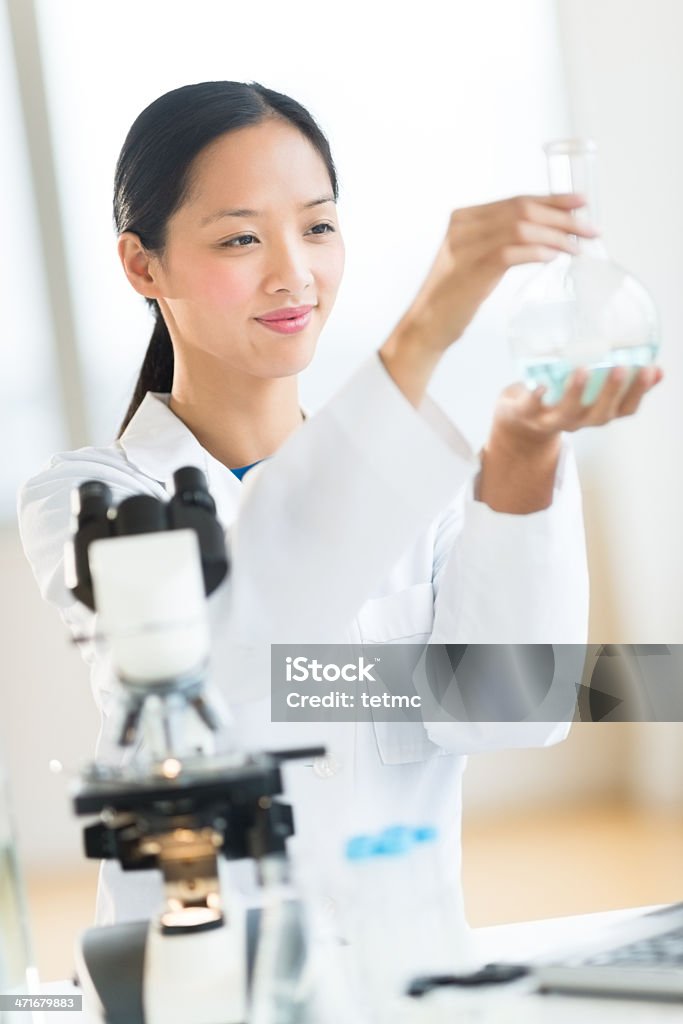 Cientista sorrindo enquanto análise química solução - Foto de stock de Descoberta royalty-free