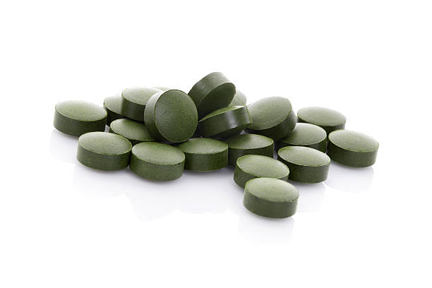 istock Green pills isolated on white background. 471680529