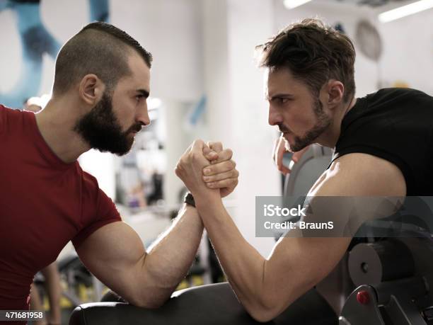 Two Young Muscular Build Men Arm Wrestling In A Gym Stock Photo - Download Image Now