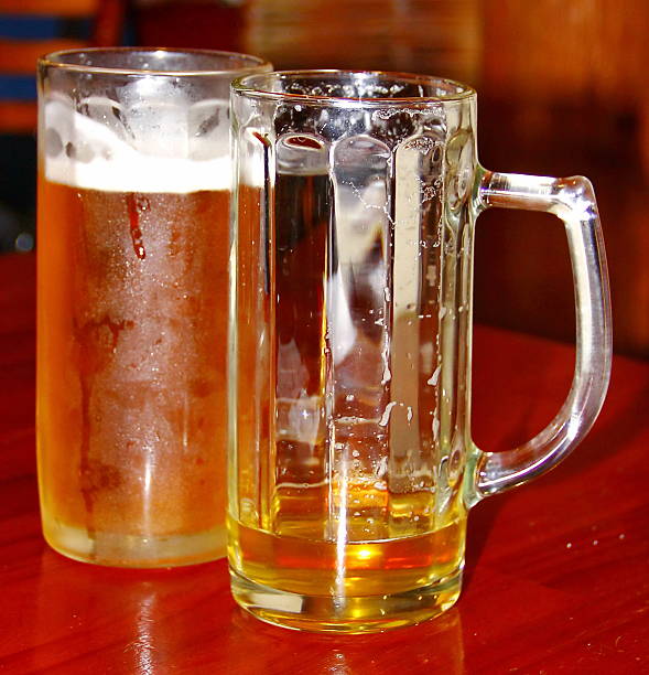 istock Two glasses of beer, empty and full 471683041