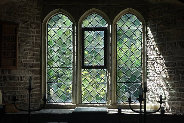 Wrought iron window bars in front of a leaded window.