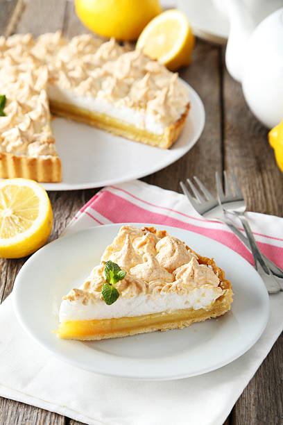 istock Lemon meringue pie on plate on grey wooden background 471685356