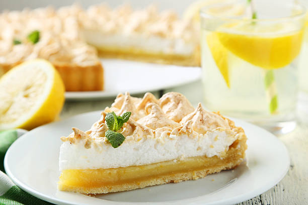 istock Lemon meringue pie on plate on white wooden background 471686078