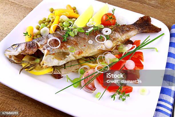 Trucha A La Parrilla Con Muy Bellas Vegetales Sobre Un Fondo De Madera Foto de stock y más banco de imágenes de Ajo