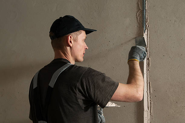 istock Woker fixes a guide to align the walls with stucco 471687412
