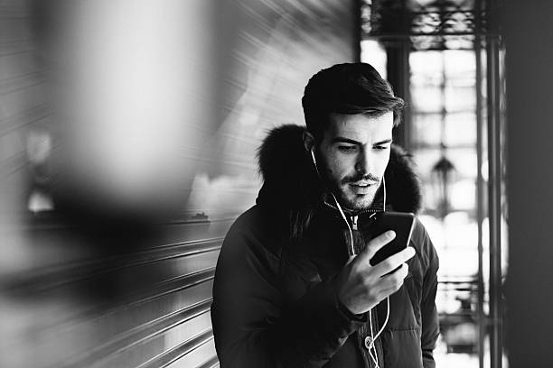 Photo of boy on the street listening music on the smart phone