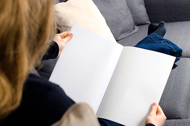 istock Reading a blank brochure in the living room on a couch 471689178
