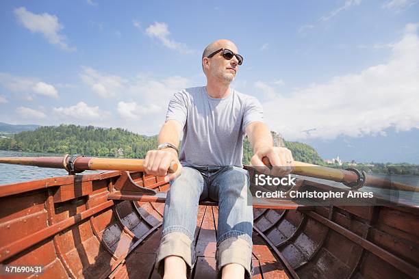 Photo libre de droit de Homme Dâge Mûr Aviron Bateau En Bois Sur Le Lac banque d'images et plus d'images libres de droit de 50-54 ans - 50-54 ans, Activité de plein air, Adulte