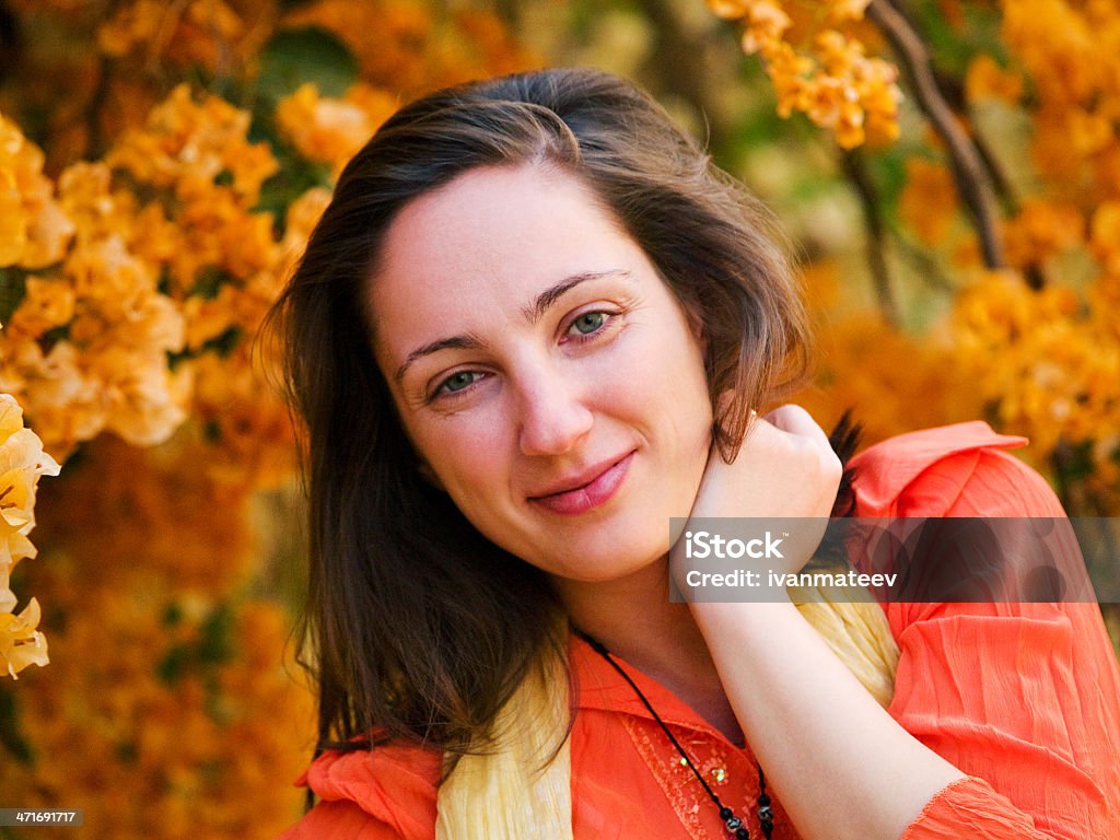 Young woman posing Young woman posing outdoors, flowers in the background Adult Stock Photo