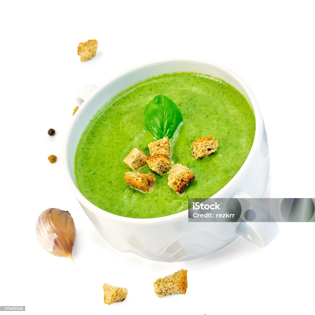 Soup puree with croutons in bowl Green soup puree in a white bowl with crackers, spinach, garlic, pepper isolated on white background 2015 Stock Photo