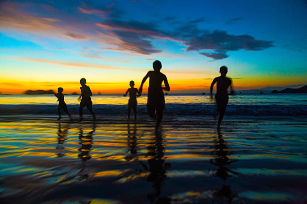 Fun running competition at the beach 5 kids running on the beach at sunset - Silhouettes costa rican sunset stock pictures, royalty-free photos & images