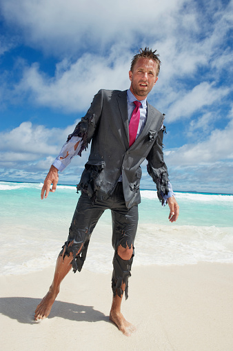 Lost castaway businessman stumbling ashore in tattered suit onto bright tropical beach