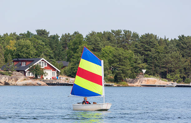 Young boy sailing optimist dinghy in Stockholm Archipelago.