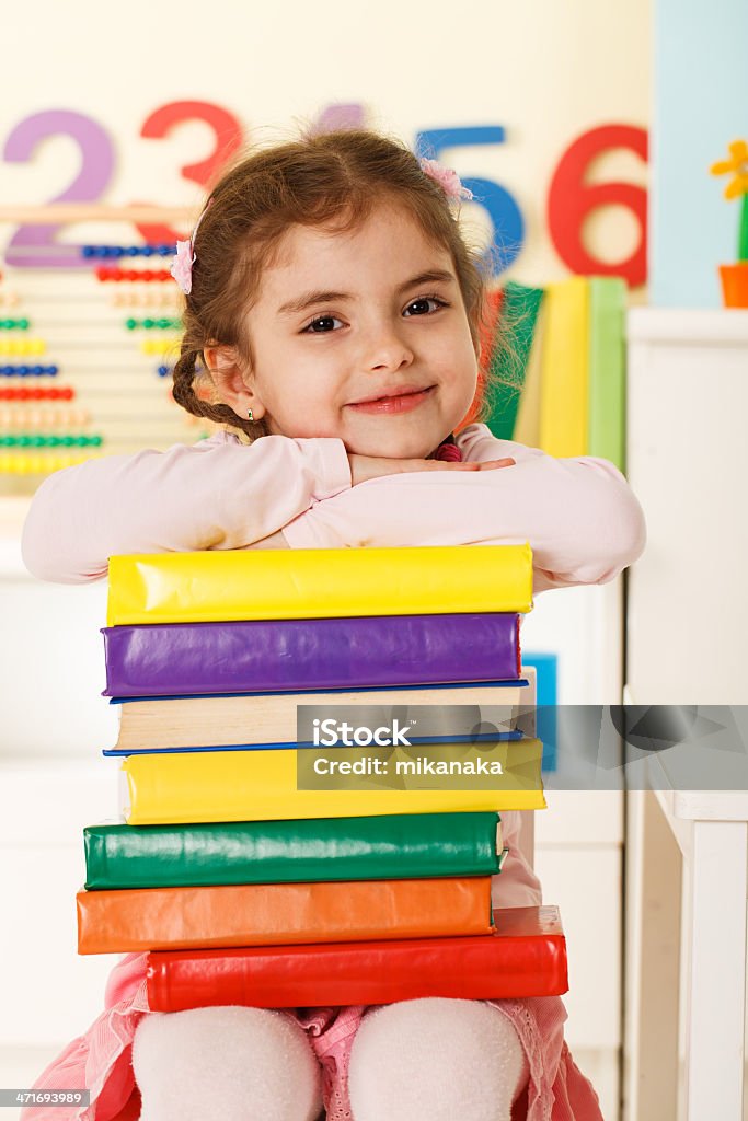 Preschooler girl with books Laughing girl with books 4-5 Years Stock Photo