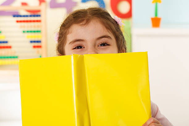istock Preschooler Girl with yellow book 471694121
