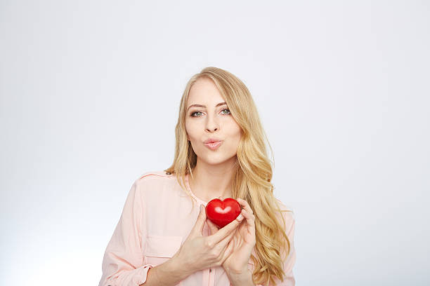 istock young blond woman holding a red heart. isolated on white 471694162