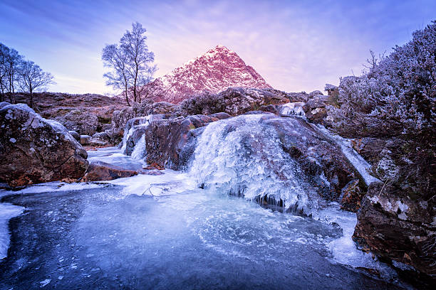 Buachaille Etive Mor Looking from Rannoch Moor across a frozen waterfall on the River Coupall to Stob Dearg and Buachaille Etive Mor at the head of Glencoe. Shot as the dawn light is hitting the peak of Stob Dearg buachaille etive mor photos stock pictures, royalty-free photos & images