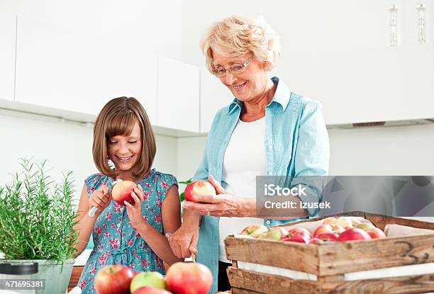 Grandma Con Manzanas Granddaughter Descamación Foto de stock y más banco de imágenes de 10-11 años - 10-11 años, 60-64 años, 8-9 años