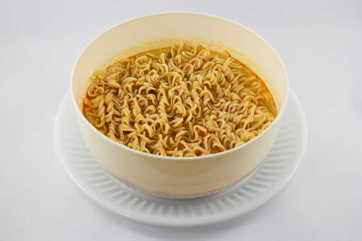 Instant noodles in white dish on white background
