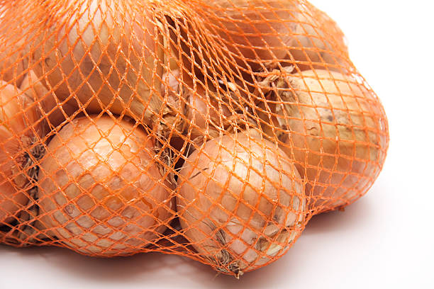 oignons dans le net - onion bag netting vegetable photos et images de collection