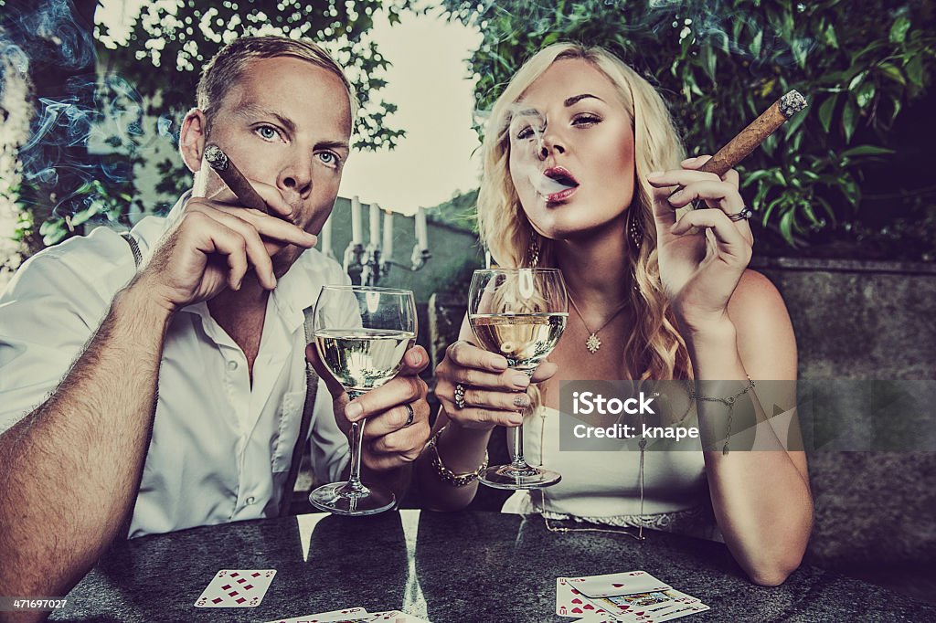 Couple having a drink and smoking cigar Couple having a drink and a cigar Cigar Stock Photo