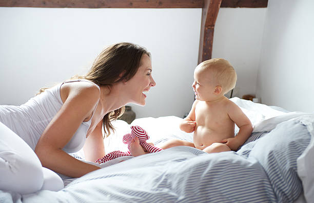 istock Mother and baby playing on bed 471697563