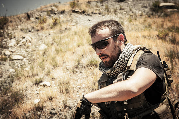 Modern Mercenary Soldier Wipes Sweat From the Effort stock photo