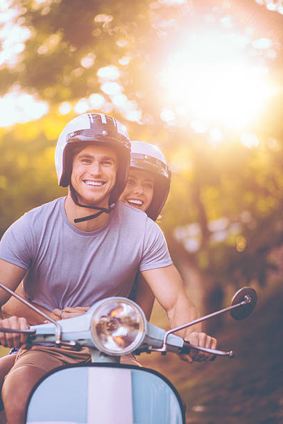 istock Young couple having a road trip together on their scooter 471700512