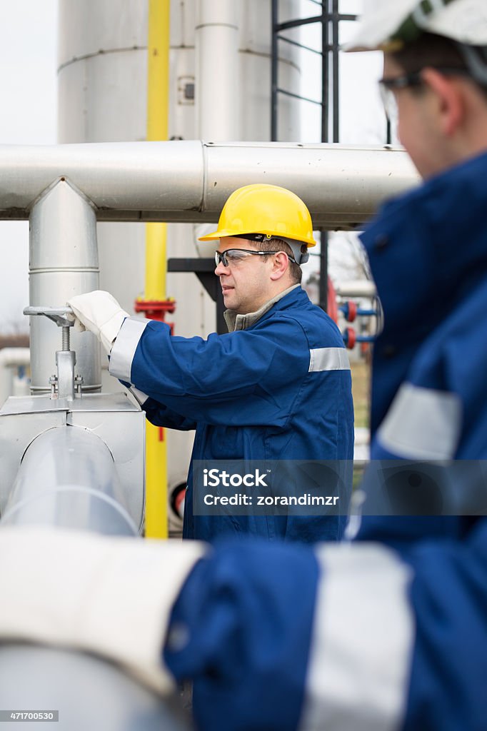 Chemical engineers inside oil refinery Two engineers working on main fuel-pump 2015 Stock Photo