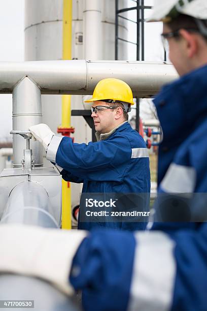 Chemical Engineers Inside Oil Refinery Stock Photo - Download Image Now - 2015, Blue-collar Worker, Chemical Plant