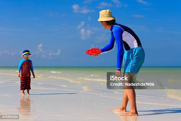 Father And Son Playing With Flying Disc At The Beach Stock Photo - Download Image Now